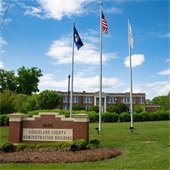 County Administration building sign with flag poles and building in background