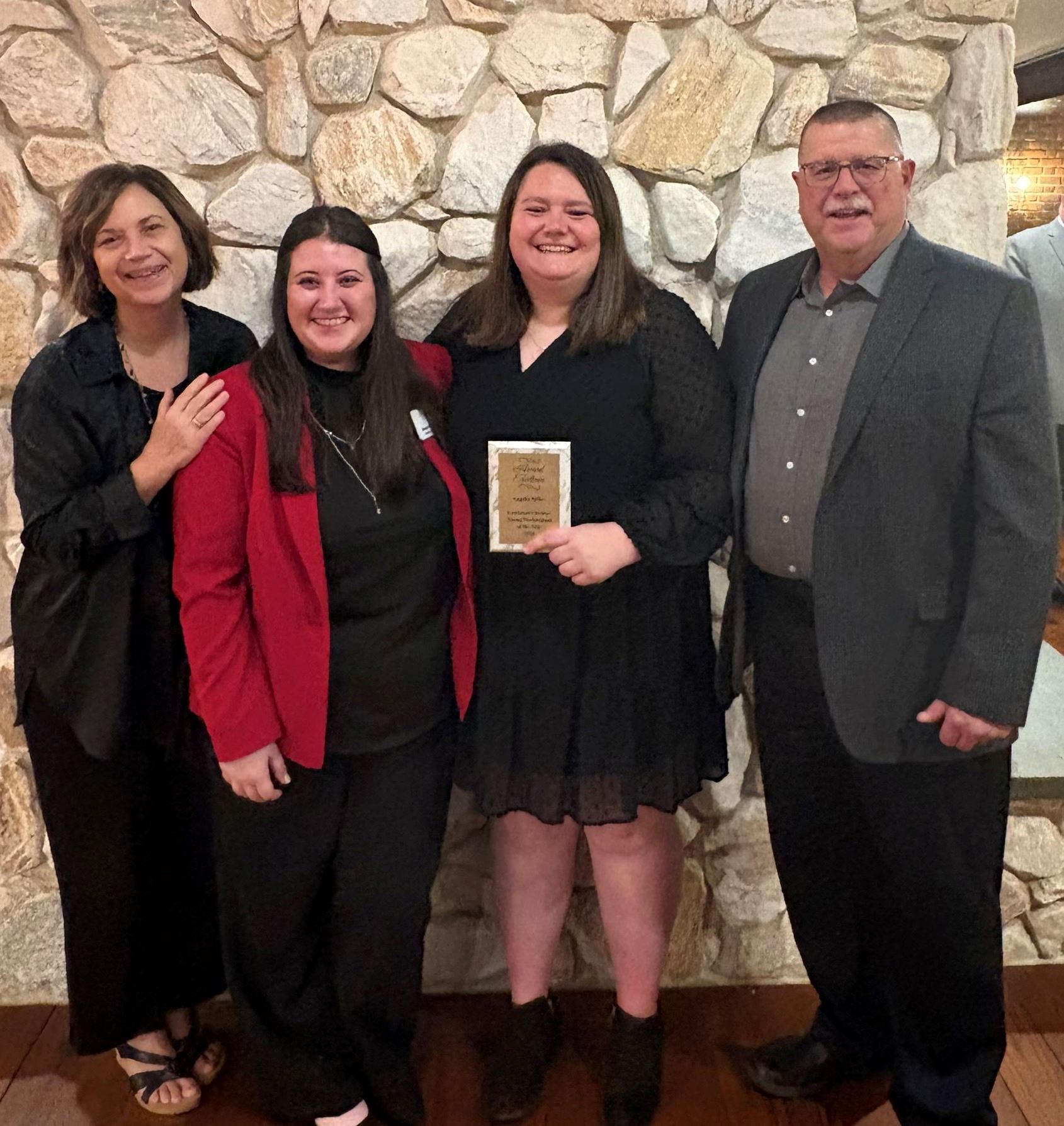 Angelia Miller with family infront of stone fireplace