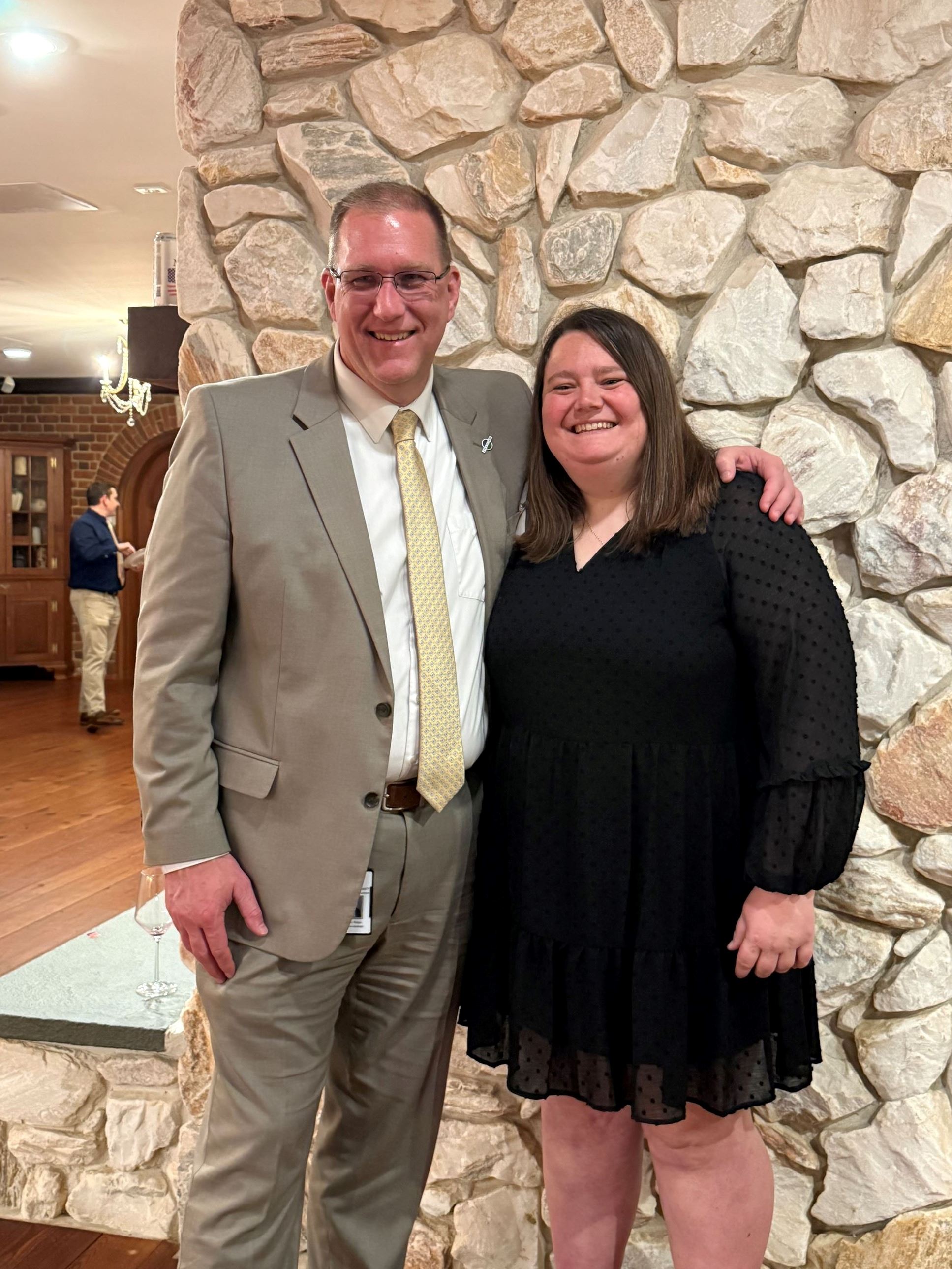 Angelia Miller and County Administrator Dr. Jeremy Raley in front of stone fireplace